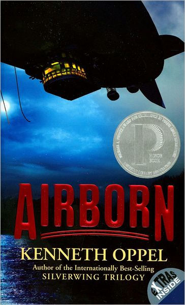 The cover of Airborn. A zeppelin crosses through a dark, cloudy blue sky, over the ocean. There are lights on in the gondala.